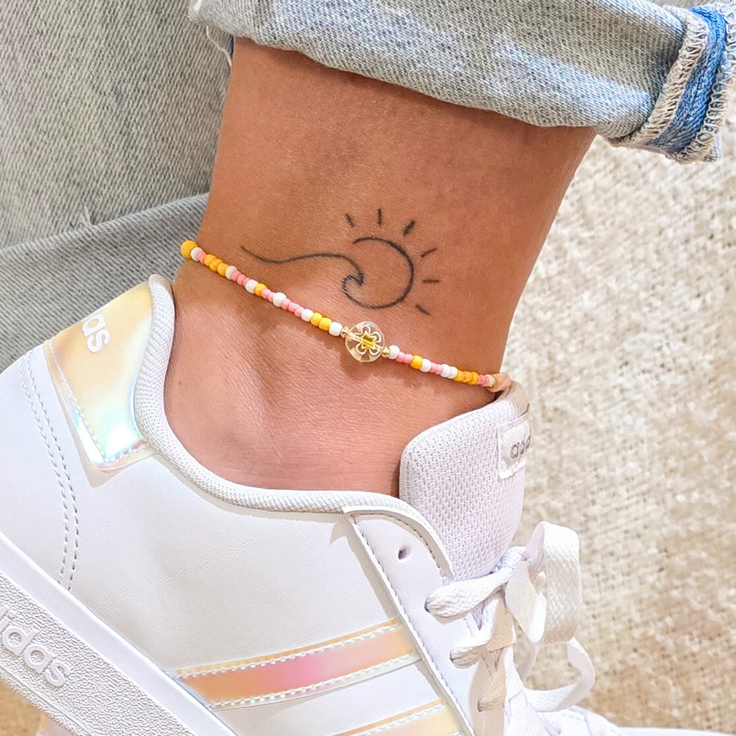 Tobillera en pie con tatuaje de una ola y zapatilla